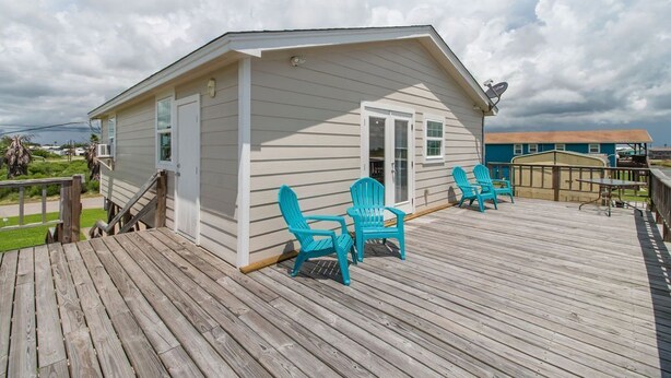A small house with a deck, two blue Adirondack chairs, and a satellite dish. - Fabulous Views, Updated, Minutes to ICW & Beach (Bay City)
