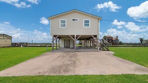A two-story house with a covered porch and a staircase leading to the upper floor. - Fabulous Views, Updated, Minutes to ICW & Beach (Bay City)