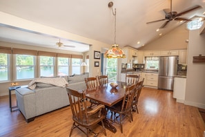 A spacious kitchen with wooden cabinets, a stainless steel refrigerator, and a dining area with a wooden table and chairs. - Lake Cottage · Two Decks · 2 Baths · 5 min Colgate, Lake Moraine Home #3 Near Colgate University (Hamilton)