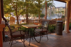 Relax in a serene outdoor space surrounded by lush trees and a beautiful building in the background.