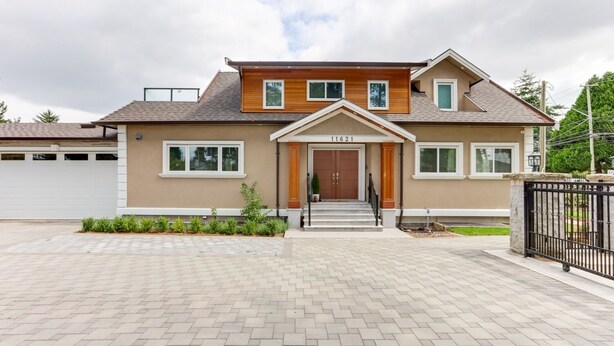 A two-story house with a front entrance, a garage, and a paved driveway. - Superb Convenient North Delta Vacation Home with 6 Bed and 6 Bath (Delta)