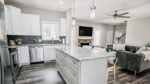 A modern kitchen with white cabinets, a granite countertop, and a built-in oven. - NEW! Pinehurst Eight Sleeps 10! (Pine Hurst)
