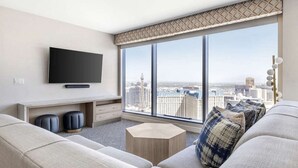 A modern living room with a large window, a flat-screen TV, a sofa, and a coffee table. - Las Vegas | Pool & Strip Access | Contemporary City Stay (Las Vegas)