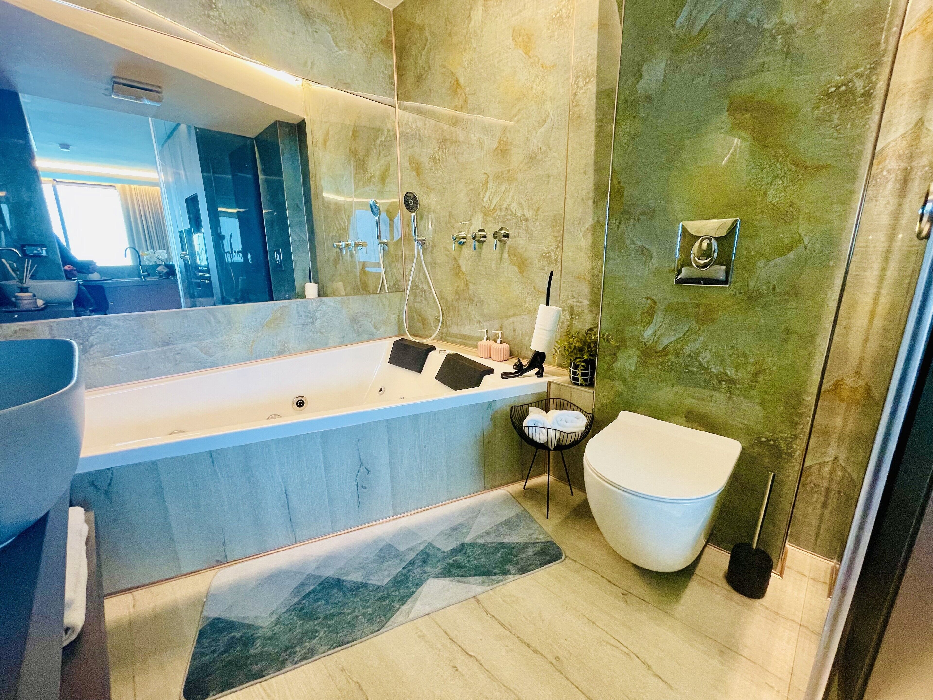 Un baño moderno con una bañera grande, un inodoro separado y una zona de ducha.