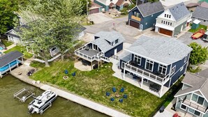A two-story house with a large deck and a dock. - SUNSET RETREAT-Luxury 4BR, 4.5BA waterfront, boat lift, best sunset on the lake! (Russells Point)