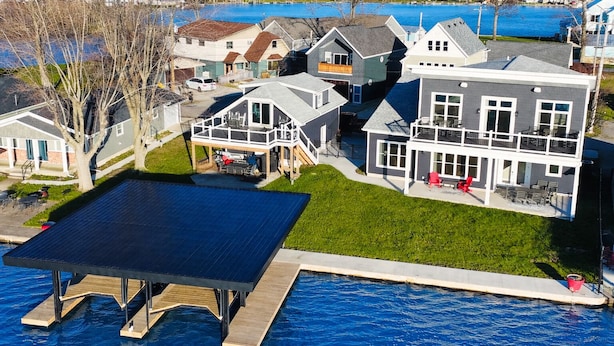 A residential area with houses, a dock, and a swimming pool. - SUNSET RETREAT-Luxury 4BR, 4.5BA waterfront, boat lift, best sunset on the lake! (Russells Point)