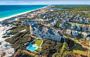 Um grande resort com vários edifícios, uma piscina e uma praia.