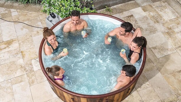 Un bain à remous pouvant accueillir six personnes, entouré de carreaux de pierre et de verdure.