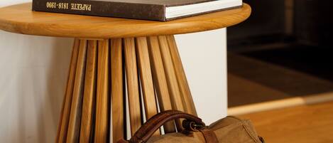 Una mesa de madera con un libro y un bolso de cuero marrón.