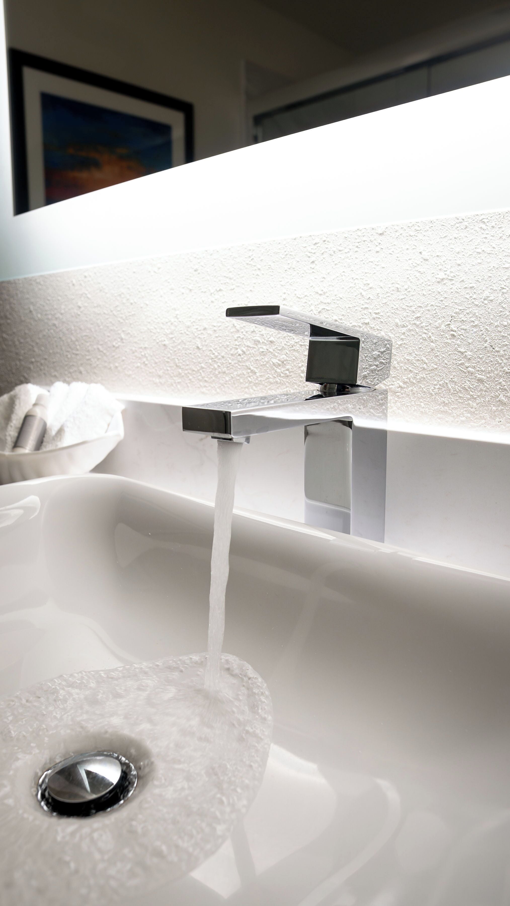 A modern bathroom sink with a chrome faucet and a white basin.