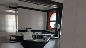 Un bagno moderno con una palette di colori bianco e nero, caratterizzato da un lavabo spazioso, uno specchio e un telefono.
