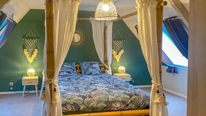 A four-poster canopy bed with a floral bedspread, two bedside lamps, and a wall-mounted dreamcatcher. - Gorgeous home in St. Pierre Langers (St. Pierre Langers)