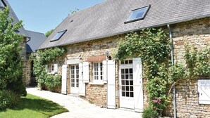 A stone building with multiple windows and doors, a paved pathway, and surrounding greenery. - Gorgeous home in St. Pierre Langers (St. Pierre Langers)