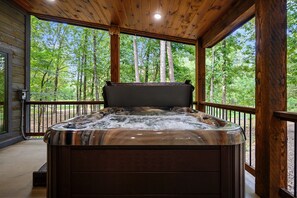A hot tub in a wooden cabin with a view of a forest. - NEW!! Escape to Modern Luxury in Broken Bow, Oklahoma! Blissful Pines Sleeps 14! (broken bow)