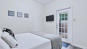 Een slaapkamer met een bed, een deur en drie motiverende kunstwerken aan de muur.