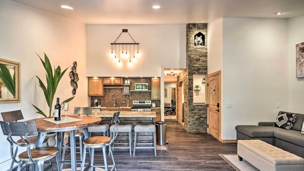 Une cuisine moderne dotée d’un îlot central, de tabourets de bar et d’une table à manger avec des chaises.