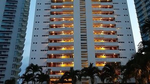 Un edificio alto con varios balcones y un elemento vertical central.