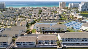 A coastal residential area with multiple-story buildings, a marina, and a large parking lot.
