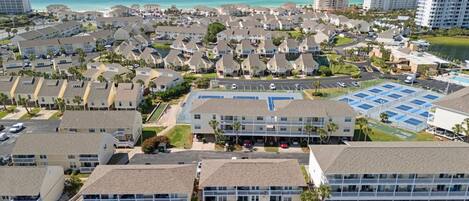 A coastal residential area with multiple-story buildings, a marina, and a large parking lot.