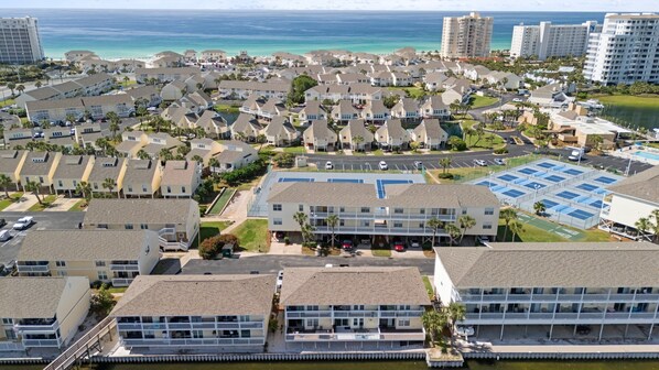 A coastal residential area with multiple-story buildings, a marina, and a large parking lot.