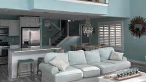A spacious living area with a high ceiling, a central island, a white sofa set, and a chandelier. - Peaceful Waterfront Family Retreat in North Ocean City (Ocean City)