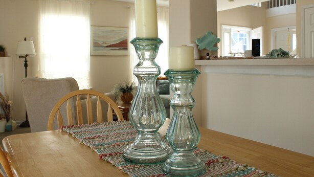 Un tavolo da pranzo con due candelabri in vetro e un sottopiattino.