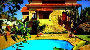 Una casa de dos pisos con una piscina delantera.