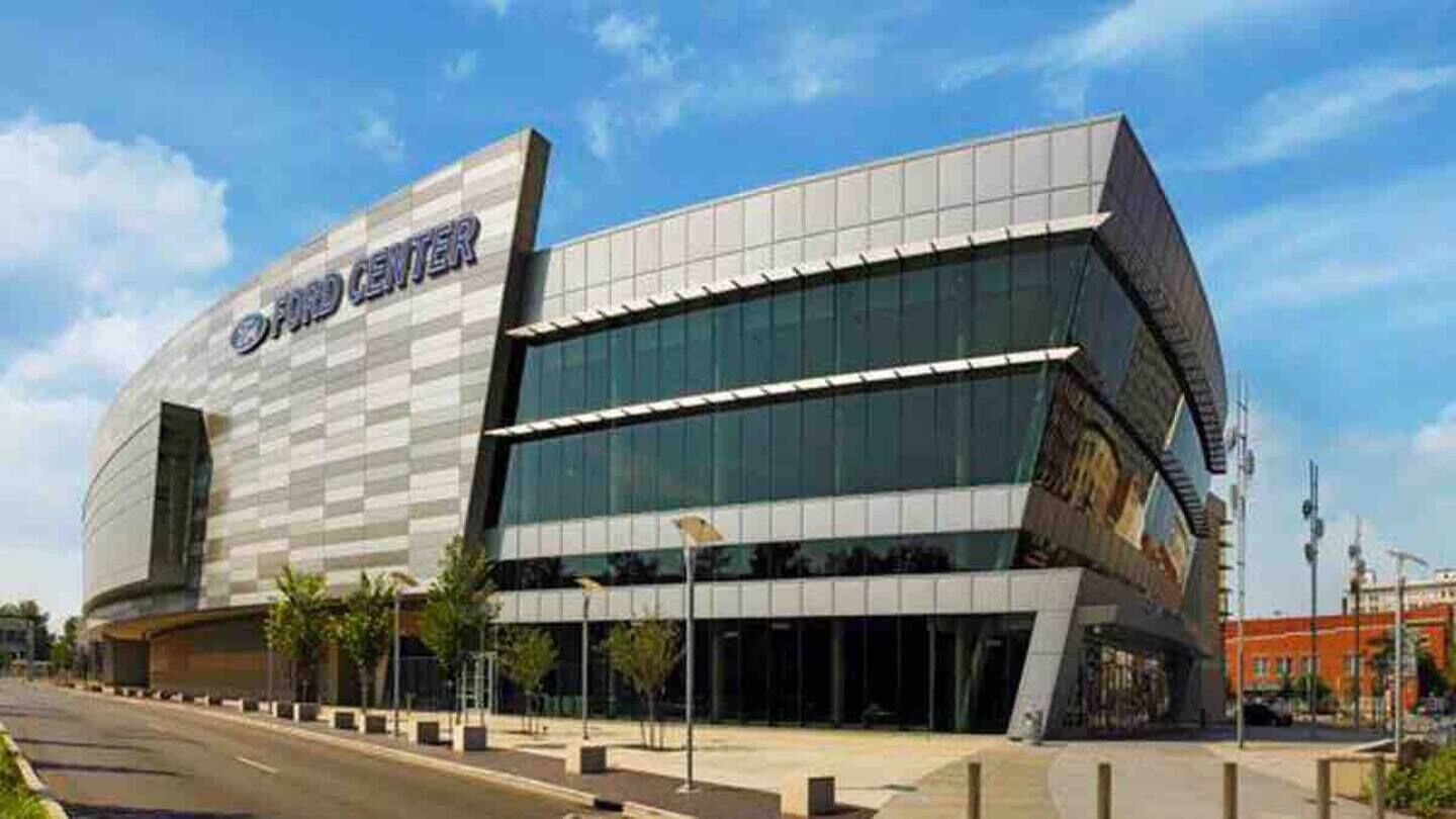 A modern building with a prominent 'Ford Center' sign, featuring a glass facade and a flat roof.