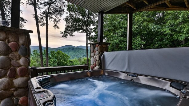 Ein Whirlpool mit Steinwand und Bergblick.