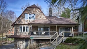 A stone house with a wooden deck and a chimney. - Fire Pit, Babbling Brook, Poker & Foosball at this 3br+ home (Lakeville)