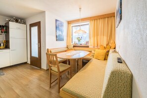 Un espacio habitable compacto con kitchenette, comedor y sofá.