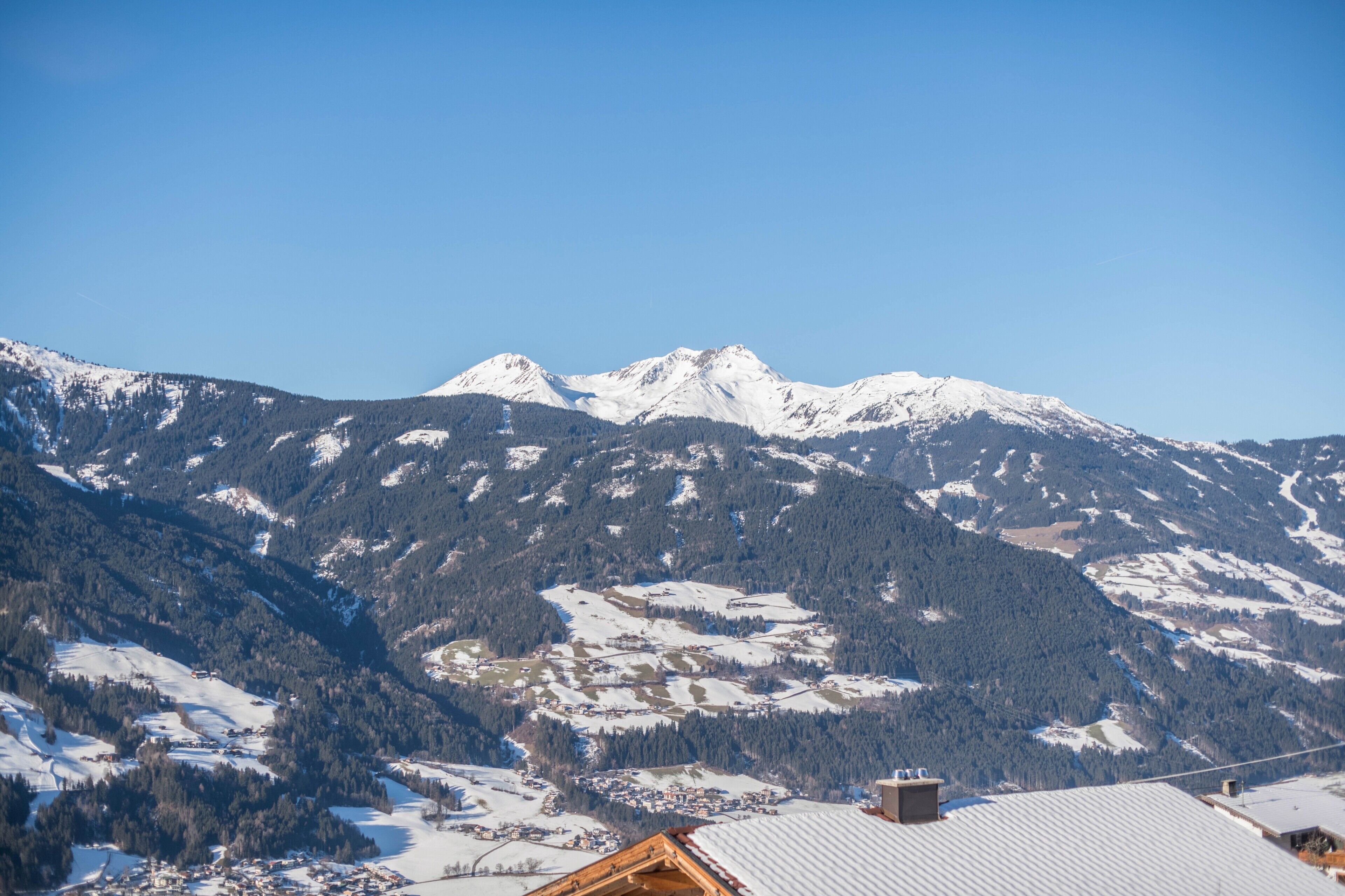 Een bergachtig landschap met besneeuwde toppen en een klein dorpje in de vallei.