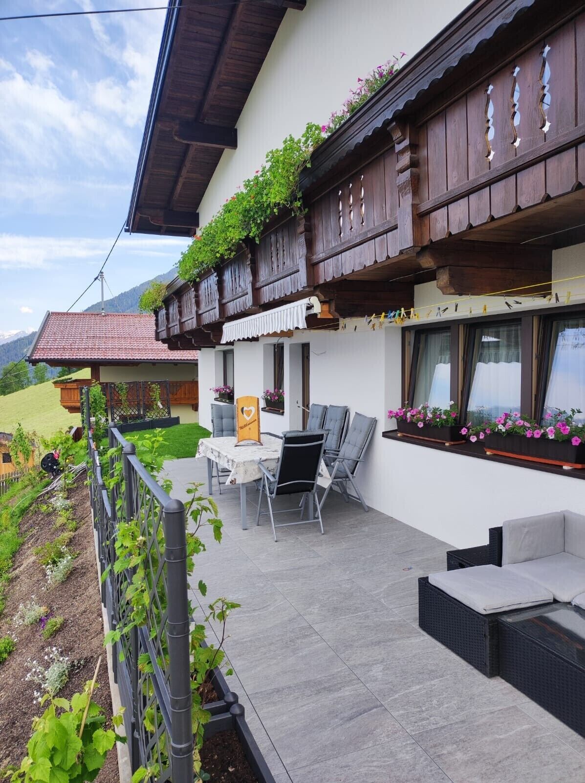 En balkon med udendørs møbler og blomsterkasser.