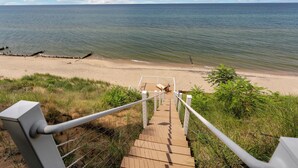 Una escalera de madera que lleva a una playa, con vista al océano.