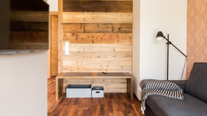 A modern living room with a wooden wall panel, a bench, a sofa, and a lamp. - Holiday Apartment "Liselotte" with Terrace, Garden & Wi-Fi (Neukirch)
