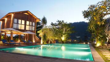 Una piscina al aire libre, sombrillas, tumbonas
