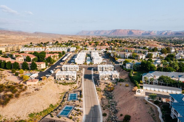 Zona residencial com vários edifícios de apartamentos, uma rua principal e montanhas ao fundo.