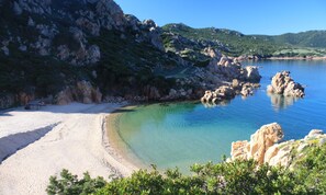 A beach with clear water, rocky outcrops, and greenery. - Villetta "Li Rocchi" with Sea View, Pool, Hot Tub, Wi-Fi, AC, and Garden (Costa Paradiso)