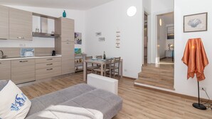 Un apartamento moderno con kitchenette, zona de comedor y sofá.