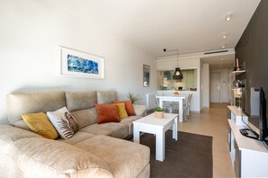 A modern living room with a sofa, coffee table, and artwork on the wall.
