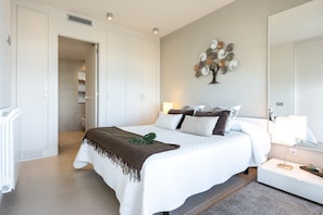 A bedroom with a bed, bedside table, lamp, and a wall decoration.