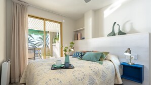 Un dormitorio con cama, mesita de noche y vistas al exterior.