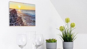 Een eethoek met een dienblad, twee glazen, een vetplant en een potplant met gele bloemen.