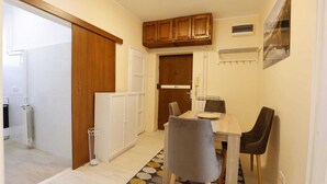 Une cuisine de taille réduite avec des meubles de rangement en bois, une table à manger avec des chaises et un radiateur.