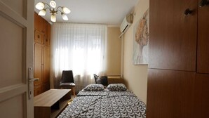 Une chambre à coucher avec un lit, une chaise, un bureau et une armoire.