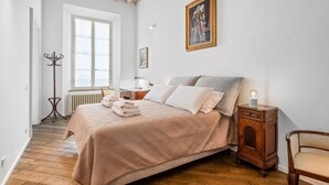 Una camera da letto con un letto, un comodino, una lampada e una finestra.