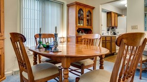 A dining room with a wooden table and chairs, a cabinet with glass doors, and a kitchen area in the background. - This newly built, modern, 2 bedroom, 1 bathroom rental condo is located on the south end of Chautauqua Institution (Chautauqua)