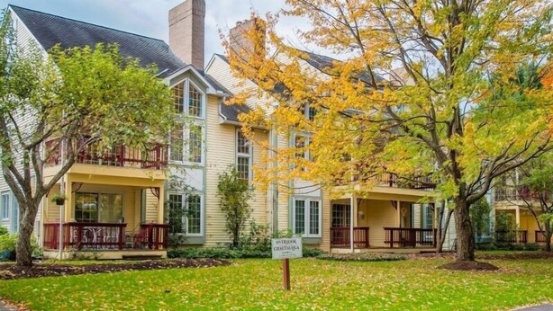 A two-story house with a porch and a sign indicating it is a guesthouse. - This newly built, modern, 2 bedroom, 1 bathroom rental condo is located on the south end of Chautauqua Institution (Chautauqua)