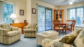 A living room with striped armchairs, a sofa, a dining table with chairs, a cabinet, and a ceiling fan. - This newly built, modern, 2 bedroom, 1 bathroom rental condo is located on the south end of Chautauqua Institution (Chautauqua)