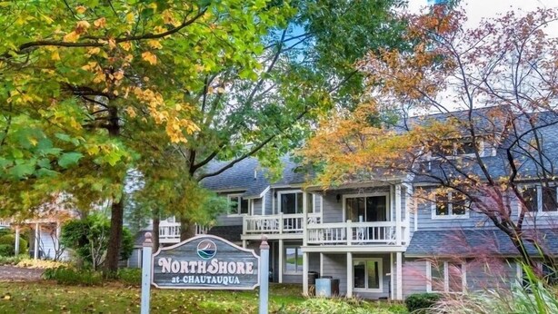 Una casa de dos pisos con un porche y un letrero que dice "North Shore at Chautauqua".